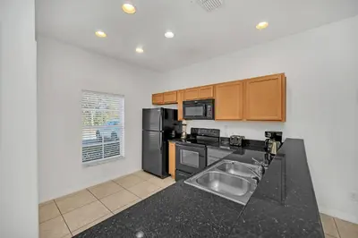 a kitchen with a sink and a black counter top at Ev30360 - Encantada Villa in Kissimmee