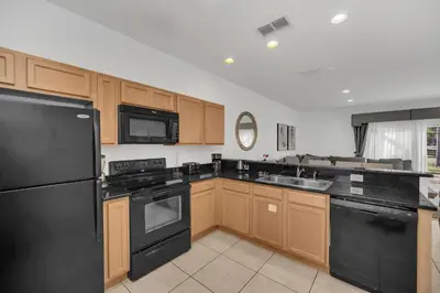 a kitchen with black appliances and wooden cabinets at Ev30360 - Encantada Villa in Kissimmee