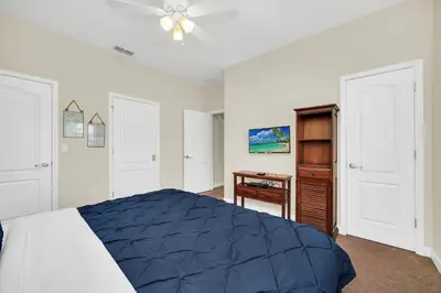 a bedroom with a blue bed and a desk at Ev8940 - Magic Palms Retreat in Kissimmee