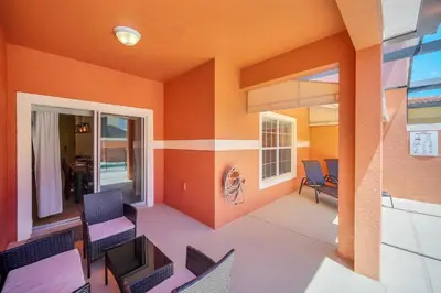 a living room with orange walls and chairs at Ev8940 - Magic Palms Retreat in Kissimmee