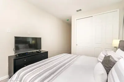 a bedroom with a bed and a flat screen tv at Ev9043 - Solara Prestige Villa in Orlando