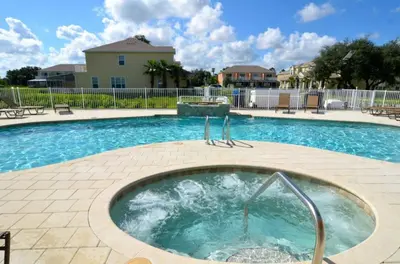 a swimming pool with a hot tub in the middle at Ev1445 - The Palm Retreat in Orlando