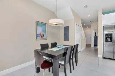 a dining room with a black table and chairs at Ev1445 - The Palm Retreat in Orlando