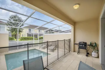 a balcony with a pool and a table and chairs at Ev1445 - The Palm Retreat in Orlando