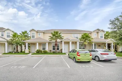 two cars parked in a parking lot in front of a house at Ev1445 - The Palm Retreat in Orlando