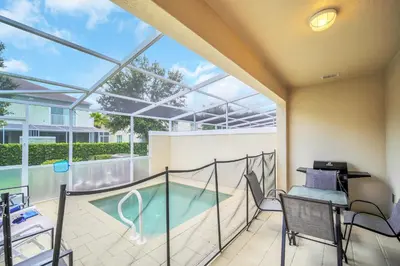 a balcony with a pool and a table and chairs at Ev1447 - The Retreat Villa in Orlando