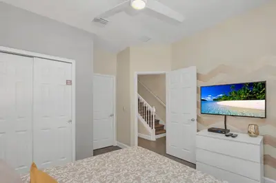 a bedroom with a bed and a flat screen tv at Ev1511 - The Serenity Villa in Orlando