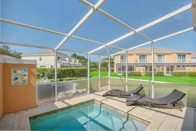 a swimming pool with two chairs in a building at Ev1511 - The Serenity Villa in Orlando