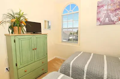 a bedroom with a green dresser with a bed and a window at Ev1915 - Sunset Glen Villa in Orlando