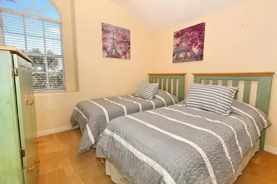 two beds in a room with a window at Ev1915 - Sunset Glen Villa in Orlando