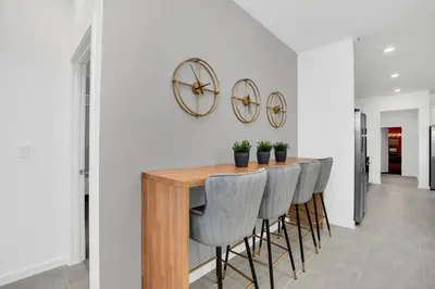 a dining room with a table with chairs and a clock at Ev2395 - Grand Haven Retreat in Kissimmee