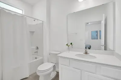 a white bathroom with a toilet and a sink at Ev2395 - Grand Haven Retreat in Kissimmee