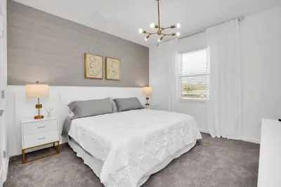 a white bedroom with a large bed and a window at Ev2395 - Grand Haven Retreat in Kissimmee