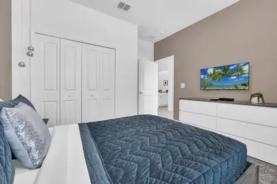 a white bedroom with a bed and a kitchen at Ev2529 - Grand Orchid Retreat in Kissimmee