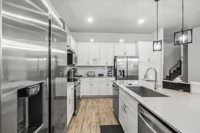 a kitchen with white cabinets and stainless steel appliances at 2558Shanti in Kissimmee