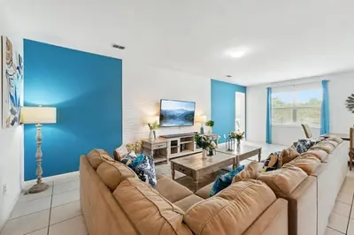 a living room with blue walls and a large couch at Ev2576 - Lakeside Adventure Villa in Kissimmee