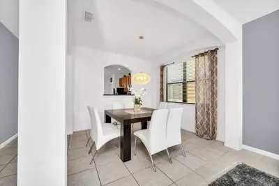 a dining room with a table and white chairs at Ev2628 - Veranda Palms Hideaway in Kissimmee