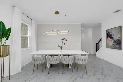 a white dining room with a white table and chairs at Ev2669 - Sunshine Escape Villa in Kissimmee