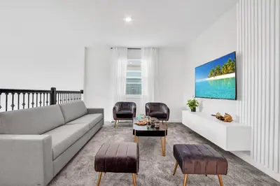 a living room with a gray couch and chairs at Ev2669 - Sunshine Escape Villa in Kissimmee