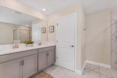 a bathroom with two sinks and a white door at Ev2707 - Magic Getaway Villa in Kissimmee
