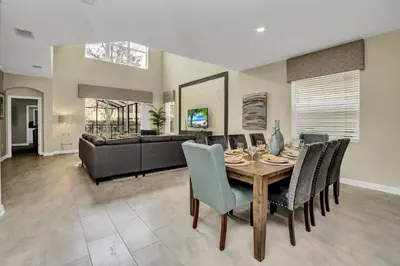 a dining room with a table and chairs and a couch at Ev2755Book - Golden Horizon Villa in Kissimmee