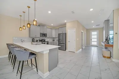 a large kitchen with white cabinets and a large island at Ev2826 - Magical Horizon Villa in Kissimmee