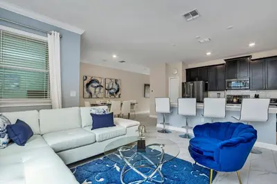 a living room with a white couch and a blue chair at Ev2861 - Sunshine Grove Villa in Kissimmee