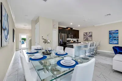 a dining room and living room with a glass table and chairs at Ev2861 - Sunshine Grove Villa in Kissimmee
