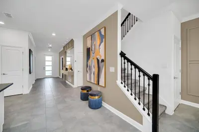 a hallway with a staircase in a home with white walls at Ev2900 - Sunset Cove Retreat in Kissimmee