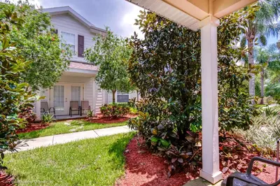 a house with a garden and a porch at Ev014 - Lucaya Retreat in Kissimmee