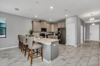 a kitchen with a large island with bar stools at Ev2909 - Storey Lake Haven in Kissimmee