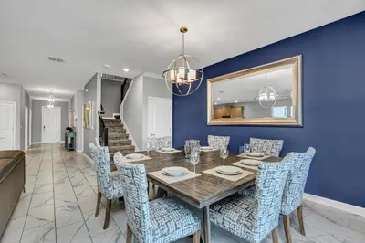 a dining room with a wooden table and blue walls at Ev2909 - Storey Lake Haven in Kissimmee
