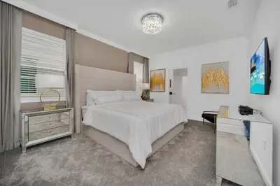 a white bedroom with a large bed and a desk at Ev2989 - Serenity Palms Villa in Kissimmee