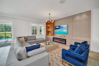a living room with a couch and two blue chairs at Ev2989 - Serenity Palms Villa in Kissimmee