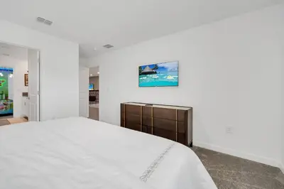 a bedroom with a large bed and a painting on the wall at Ev2989 - Serenity Palms Villa in Kissimmee