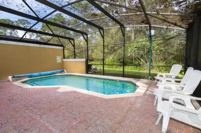 a swimming pool in a greenhouse with chairs around it at Ev3000 - Paradise Hideaway in Orlando