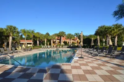 a pool at a resort with chairs and trees at Ev3000 - Paradise Hideaway in Orlando