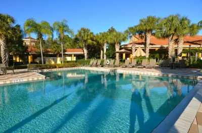 a swimming pool with palm trees and a house at Ev3000 - Paradise Hideaway in Orlando