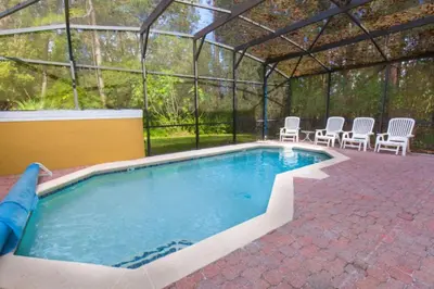 a swimming pool in a tent with chairs and a table at Ev3000 - Paradise Hideaway in Orlando