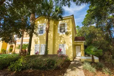 a yellow house with a white door and trees at Ev3000 - Paradise Hideaway in Orlando