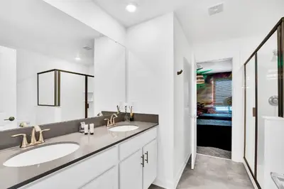 a white bathroom with two sinks and a mirror at Ev3009 - Grand View Retreat in Kissimmee