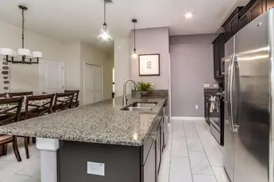 a kitchen with a sink and a stainless steel refrigerator at Ev3097 - Lakeside Serenity Villa in Kissimmee