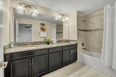 a bathroom with a tub and a sink and a bath tub at Ev3097 - Lakeside Serenity Villa in Kissimmee