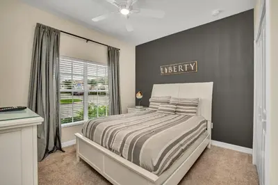 a bedroom with a large bed and a window at Ev3097 - Lakeside Serenity Villa in Kissimmee