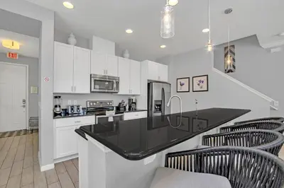 a kitchen with white cabinets and a black counter top at Ev3115 - Sunset Bay Villa in Kissimmee