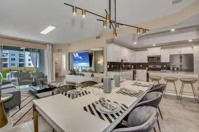 a kitchen and living room with a table and chairs at Ev101 - The Luxe Loft in Kissimmee