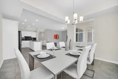 a white dining room with a table and white chairs at Ev3180 Unit203 - Captains Cove Villa in Kissimmee