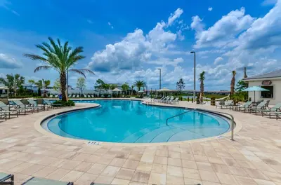 a swimming pool at a resort with chairs and palm trees at Ev4152 - Aventure Oasis in Kissimmee