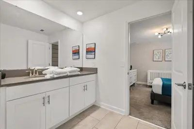 a white bathroom with a sink and a bed at 4324Prolouge in Kissimmee