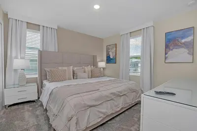 a white bedroom with a large bed and a desk at Ev4568 - Storey Oasis in Kissimmee